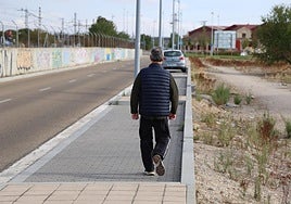 Un peatón camina por la acera interrumpida de la calle Salud. Al fondo, en uno de los tramos de estacionamiento, un vehículo aparcado que le obligará a utilizar la calzada.