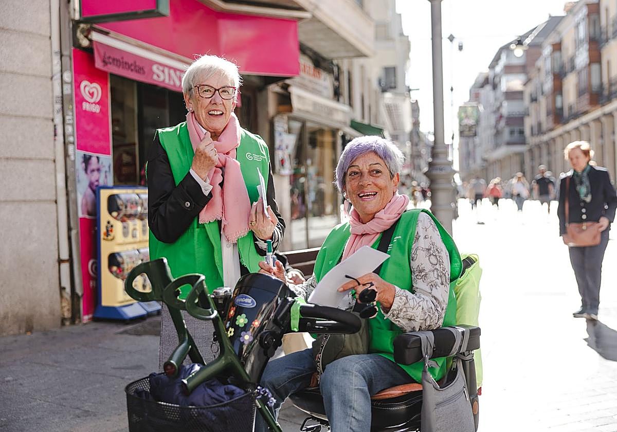 Encarna Escudero, en la silla de ruedas, con otra voluntaria, este viernes en la Calle Mayor.