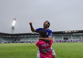 Felipe Peredo celebra uno de los goles del Palencia Cristo con un compañero del banquillo