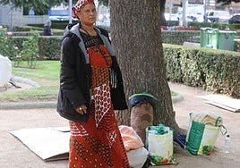 Una de las personas que pernocta al raso en los Jardillos de San Roque con sus bártulos en bolsas.