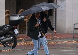 Dos personas caminan bajo sus paraguas cuando empiezan a caer las primeras gotas.