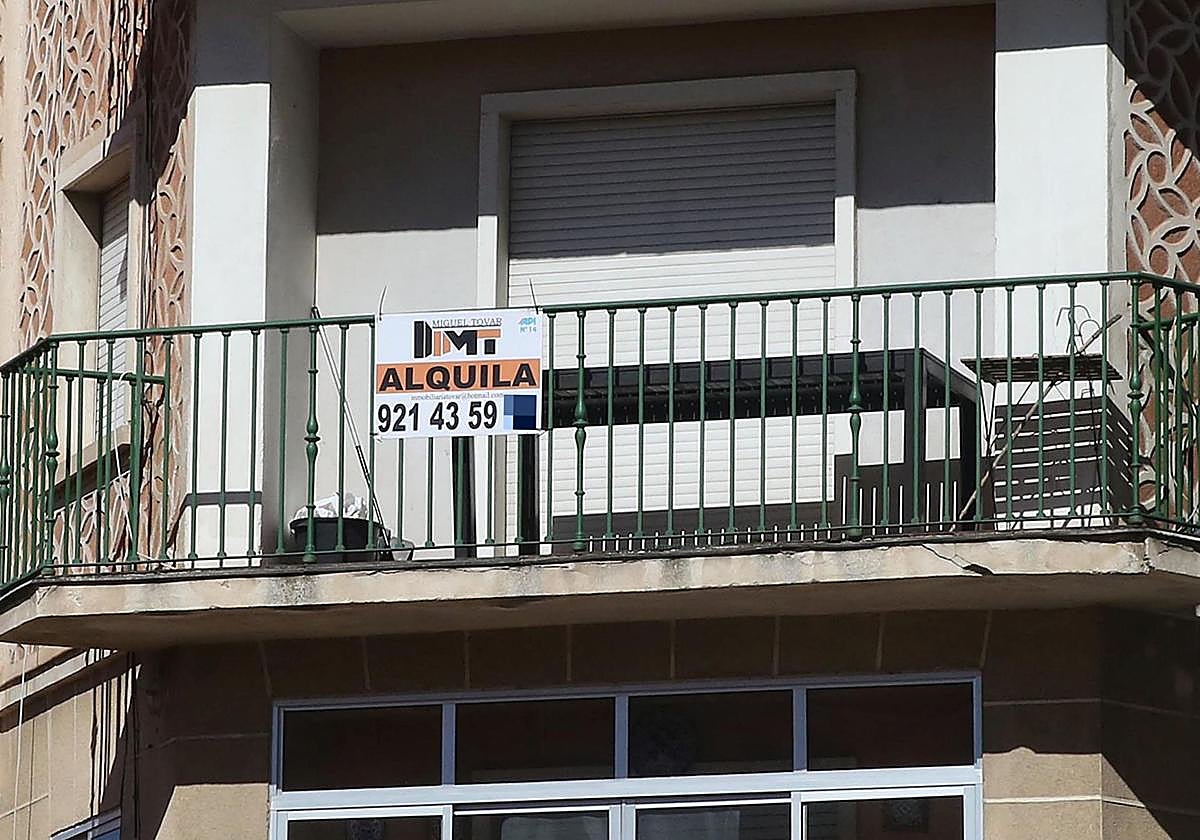 Un cartel colgado en un balcón que anuncia una vivienda en alquiler.