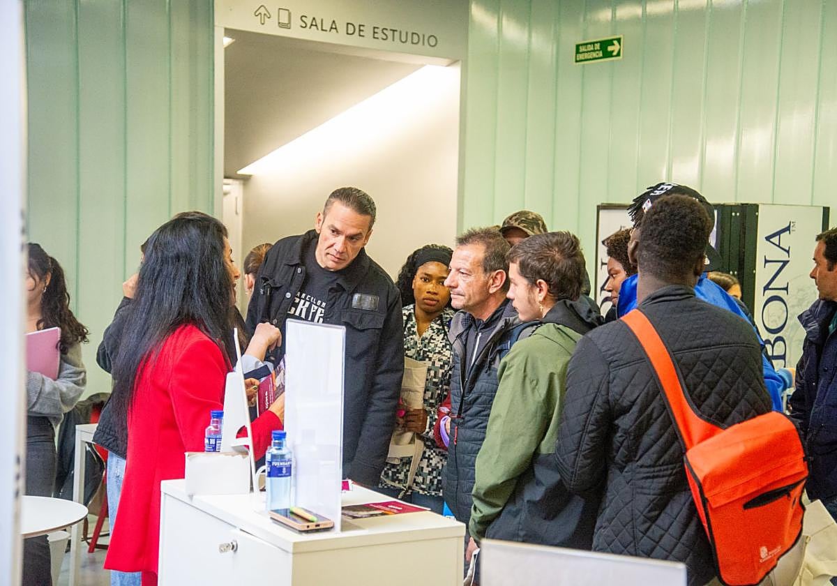 Varias personas siguen las explicaciones en el puesto de una empresa de la feria.