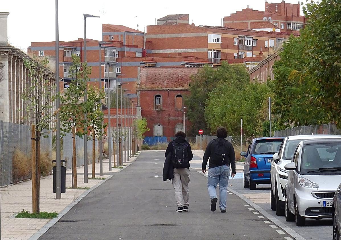 Imagen principal - Arriba, dos jóvenes pasean por una de las nuevas calles del interior del Conde Ansúrez, en la que se han colado los primeros coches. Debajo, a la izquierda, la futura plaza de la Dignidad Humana. A la derecha, un viejo grafiti en una de sus calles.