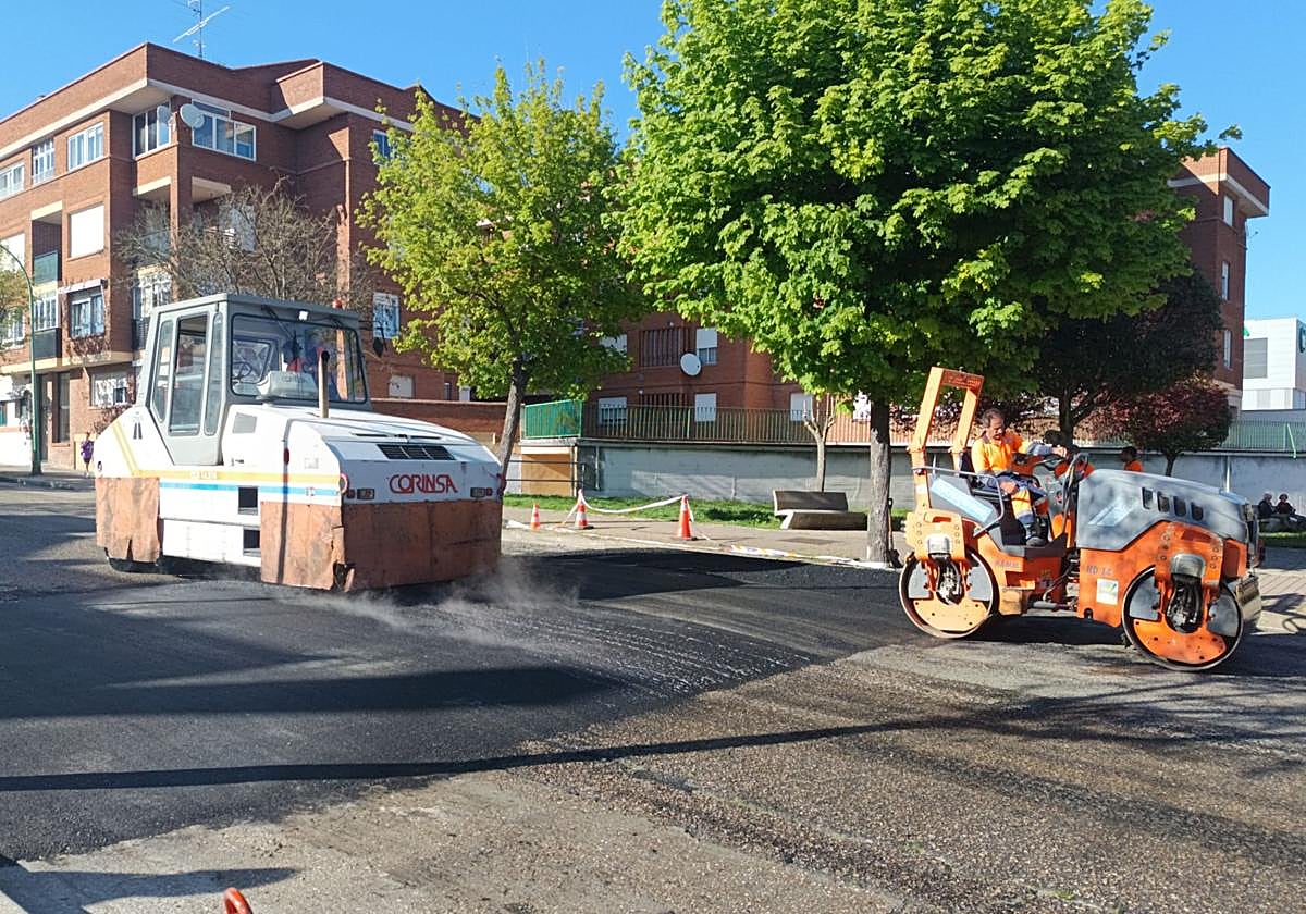 Dos máquinas trabajan en el asfaltado de un paso de peatones elevado.