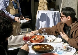 Un turista paga con tarjeta un almuerzo en un restaurante de la capital segoviana.