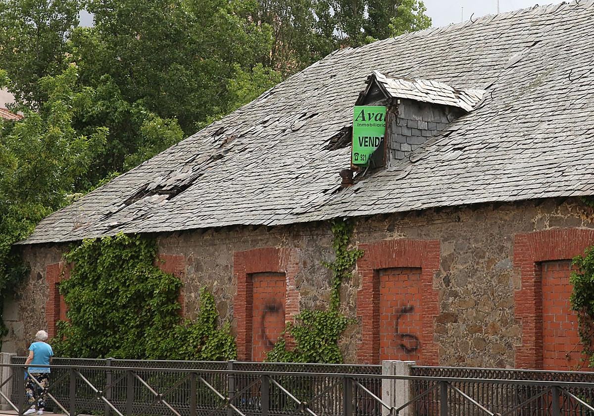 Estado actual del edificio principal de la fábrica de loza de Segovia, con un cartel que anuncia su venta.