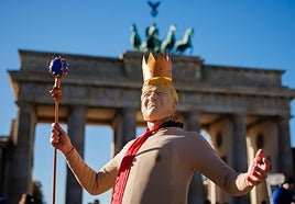 Una persona viste un disfraz de Trump con una corona en la cabeza.