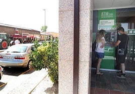 Dos personas realizan una operación en el cajero automático de Frómista.