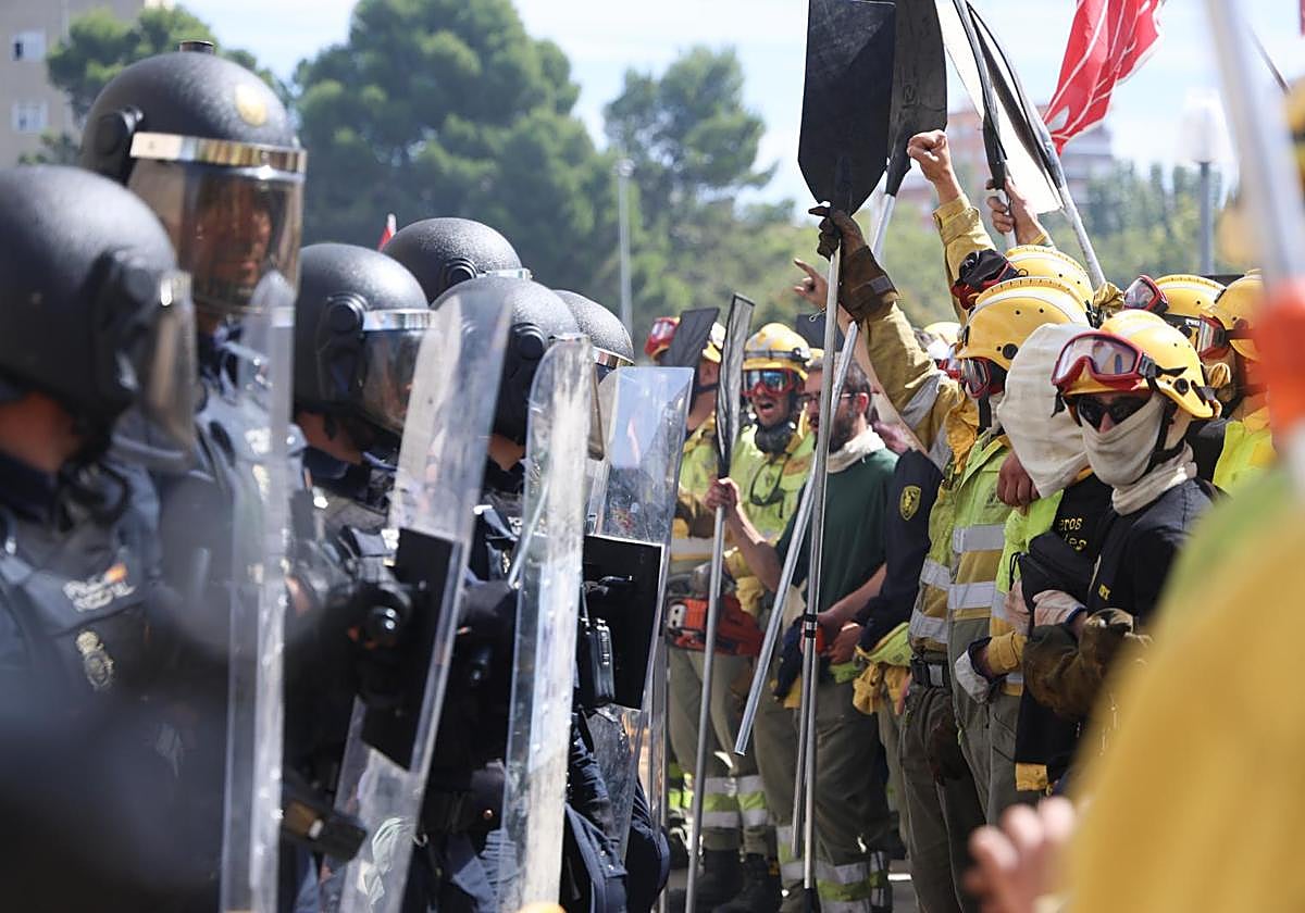 Bomberos forestales se manifiestan frente a los antidisturbios durante la protesta por la precariedad del servicio, el pasado septiembre.