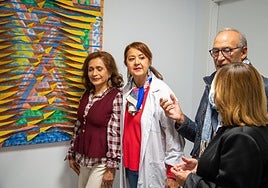 Artistas de Thieldón explican sus creaciones a la presidenta de la Asociación del Cáncer de Palencia.
