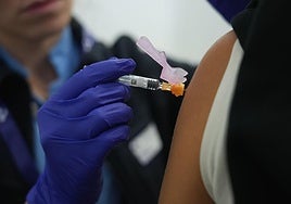 Una sanitaria inyecta una dosis de la vacuna frente a la gripe.