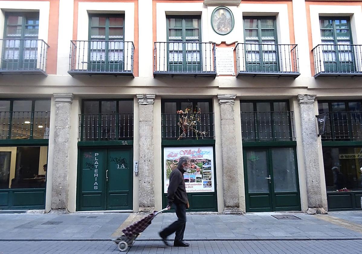 Un hombre camina frente a un bloque de viviendas turísticas en la calle Platerías.