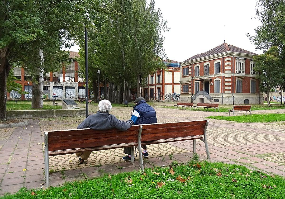 Dos hombres sentados en la entrada de la futura plaza de Antonio Piedra, en el parque de Las Norias. A la derecha, la sede de la Fundación Jorge Guillén. Detrás, el segundo chalé que ocupará el Centro Francisco Pino. Detrás, la vieja azucarera Santa Victoria.