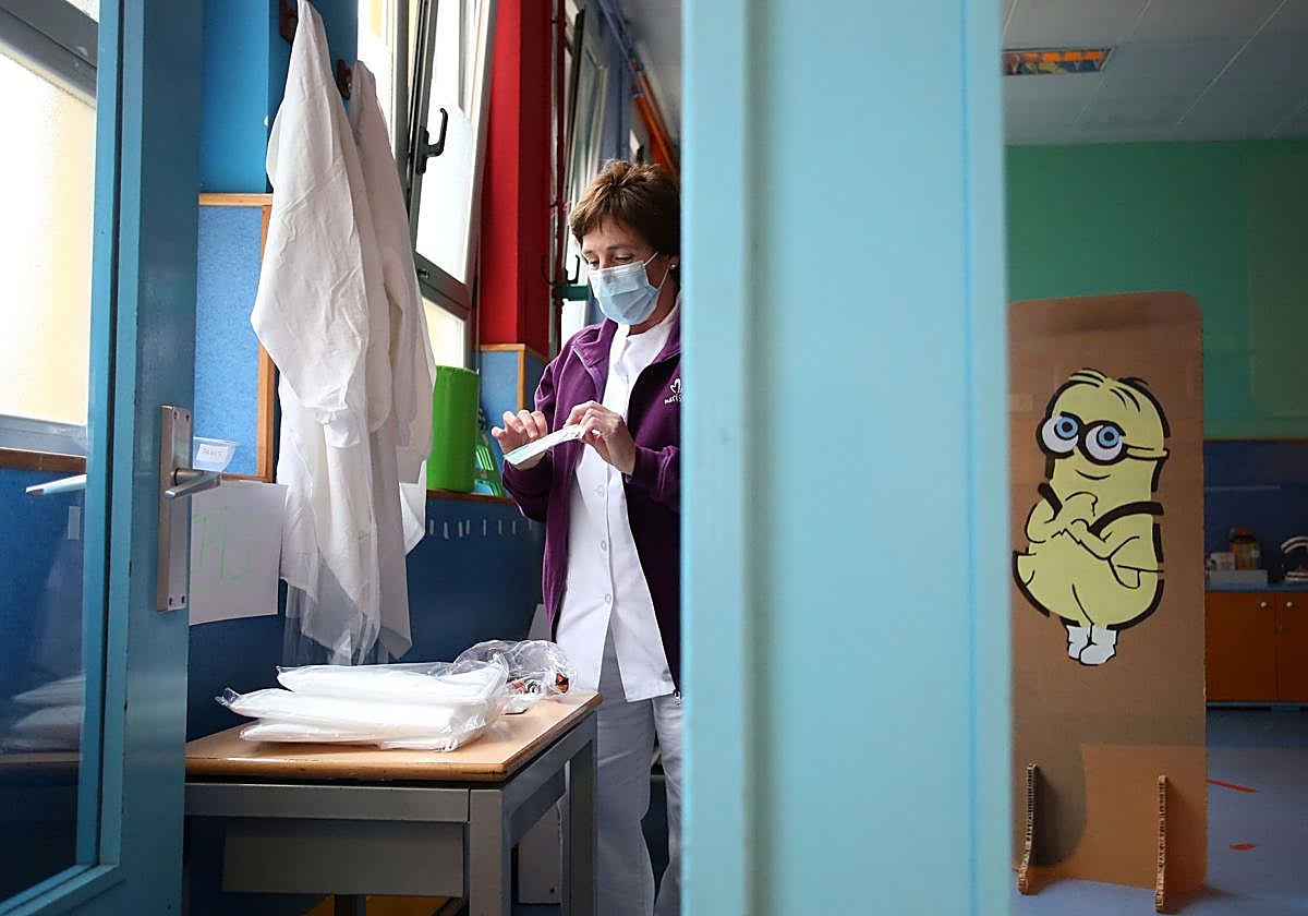 Una enfermera prepara una prueba sanitaria en un colegio.