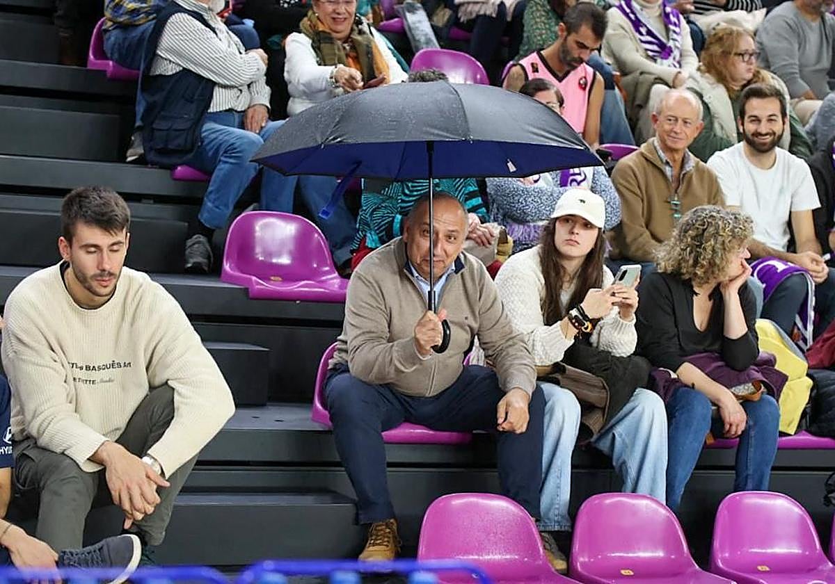 Un aficionado se protege con un paraguas de las goteras de Pisuerga.