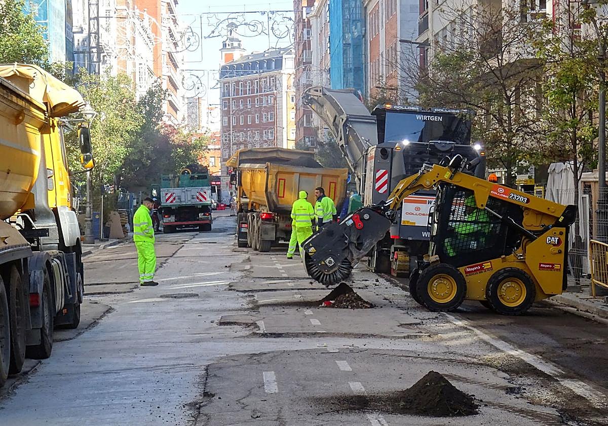 Imagen principal - Arriba, labores de fresado en Gamazo. Debajo, a la izquierda, la grúa retira un coche aparcado en la zona en obras. A la derecha, la pasarela para facilitar el paso de peatones en la plaza de Madrid.