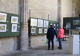 Dos visitantes recorren la exposición en el claustro de la Catedral.