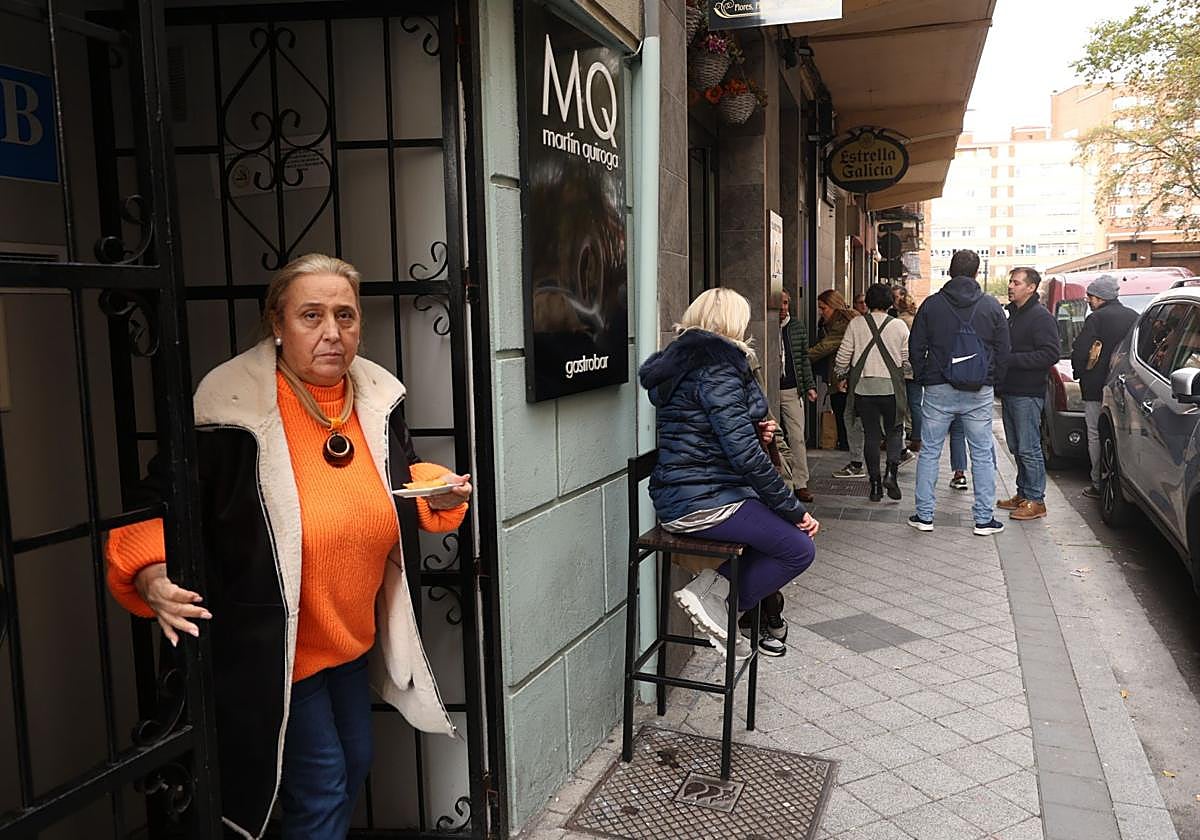 Una clienta sale del restaurante Martín Quiroga mientras otras aguardan su turno sentadas y al fondo un grupo espera de pie.