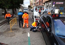 La grúa retira un coche estacionado en el tramo cortado este miércoles de la calle Estación.