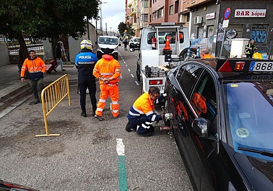 La grúa retira un coche estacionado en el tramo cortado este miércoles de la calle Estación.