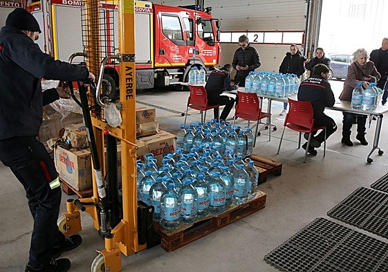 Los bomberos reparten agua durante un episodio de contaminación del agua.