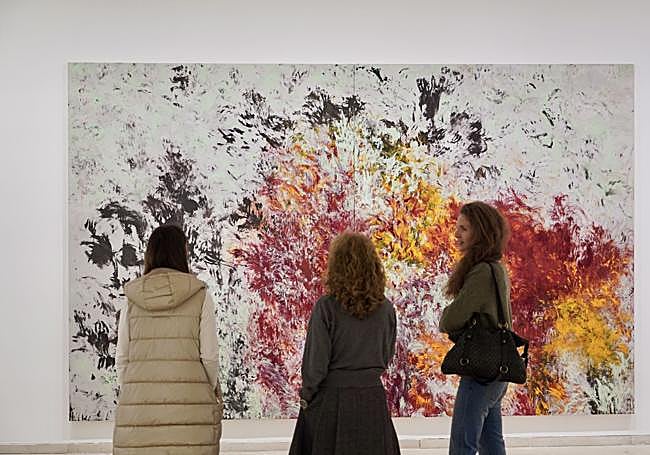 Tres visitantes contemplan una de las obras.