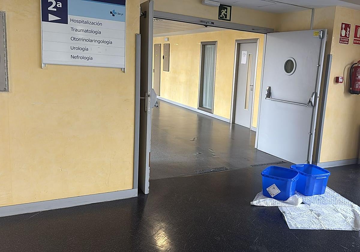 Cubos y toallas para recoger el agua de las goteras formadas este viernes en el acceso a hospitalización en el complejo asistencial de Segovia.