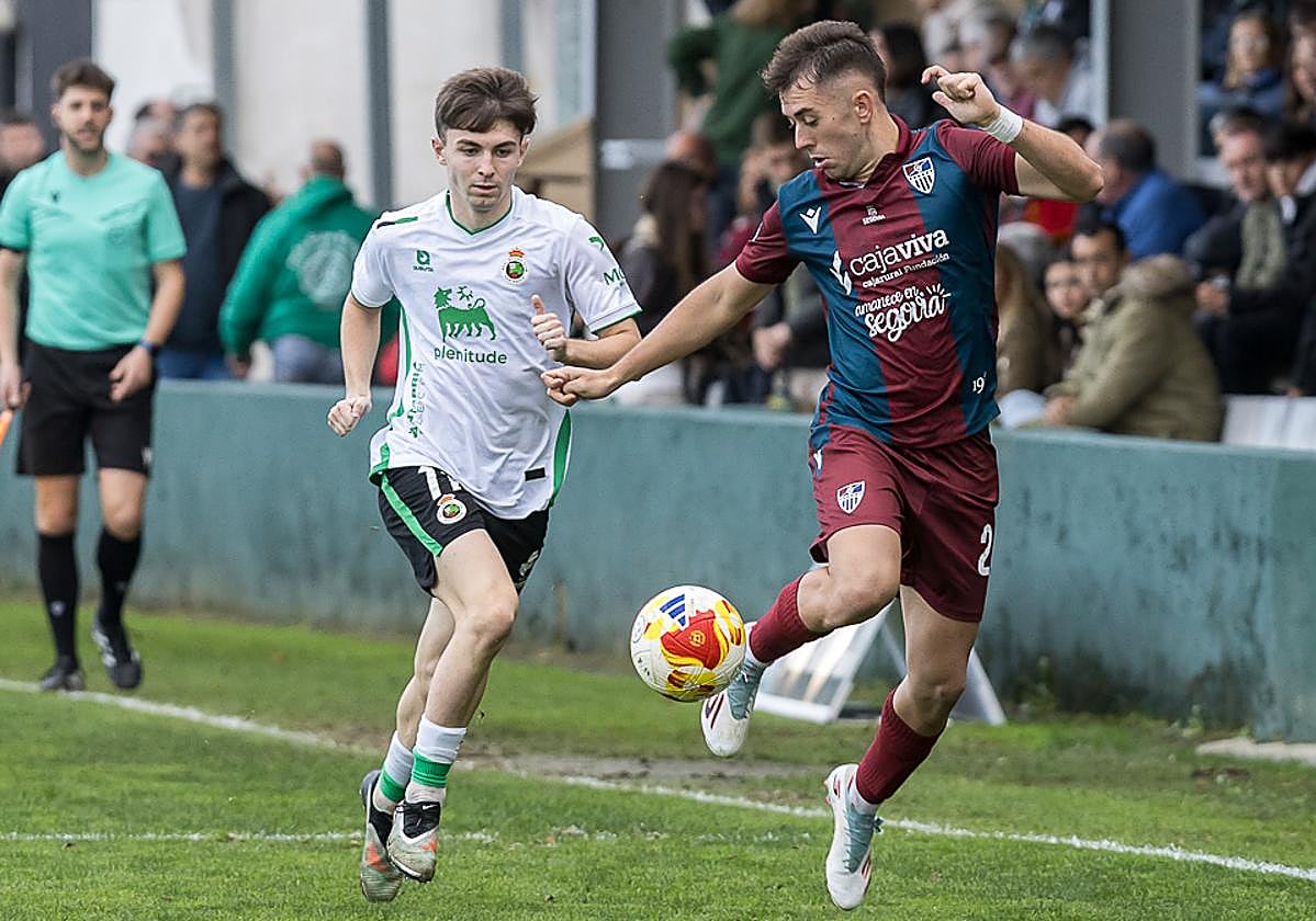 Diego Campo controla el balón perseguido por un jugador del Rayo Cantabria.
