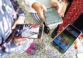 Varios escolares miran sus teléfonos móviles en una imagen de archivo.