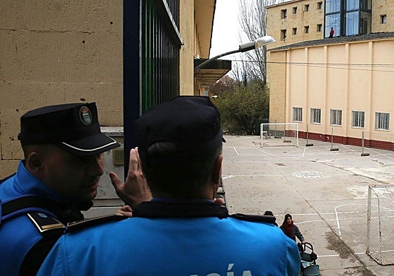 Agentes de la Policía Local de Segovia y al fondo los operarios en el tejado del edificio en obras al otro lado del patio de La Aneja.