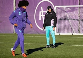 Peter Federico, muy abrigado, mientras Almada observa el entrenamiento.