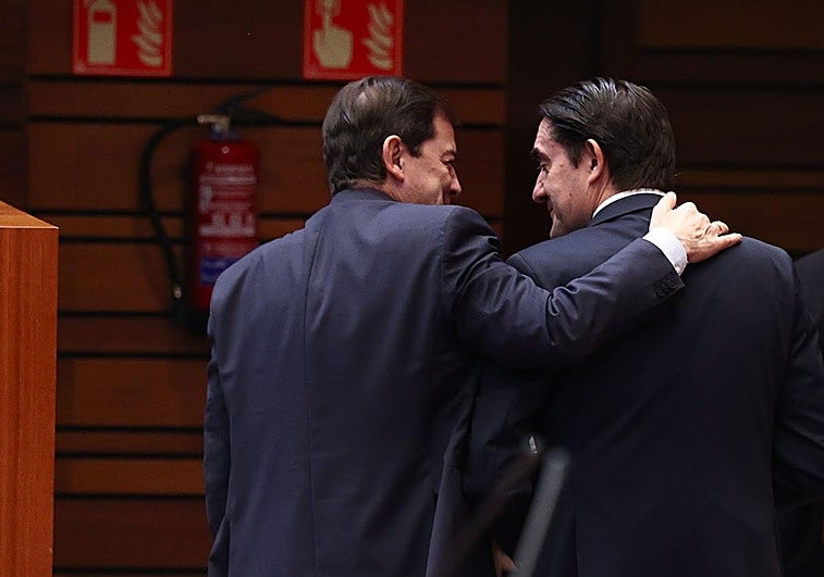 Alfonso Fernández Mañueco sale del hemiciclo con Juan Carlos Suárez-Quiñones en un momento del Pleno previo a las votaciones.