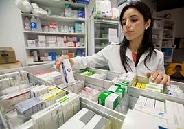Una farmacéutica busca medicamentos.