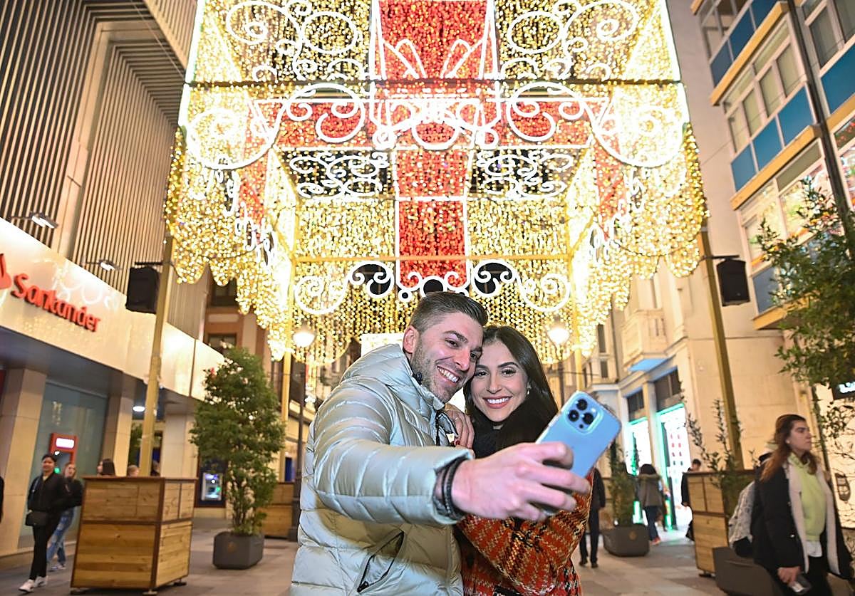 Una pareja se hace un selfie con la iluminación navideña de la calle Santiago en años anteriores.