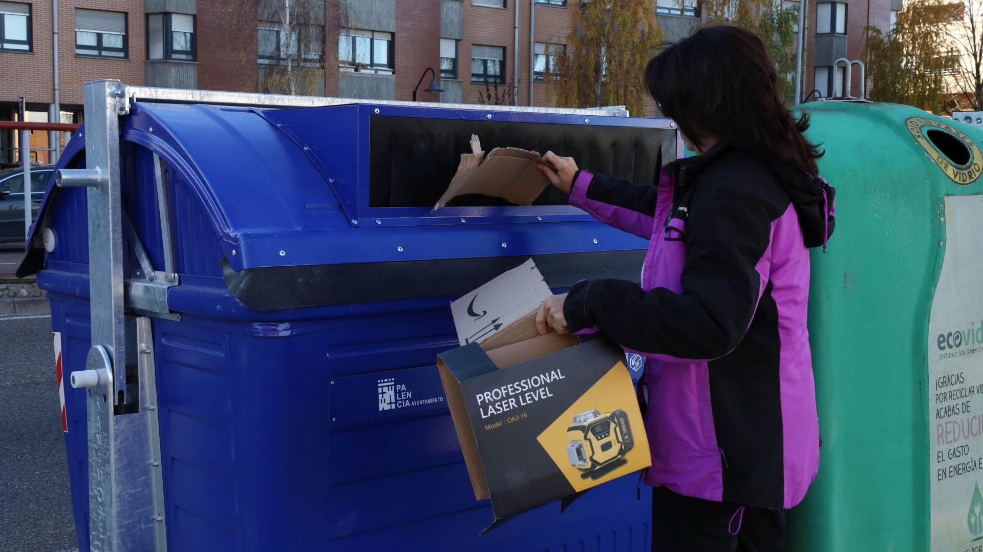Una mujer arroja cartones en un contenedor en Derechos Humanos.
