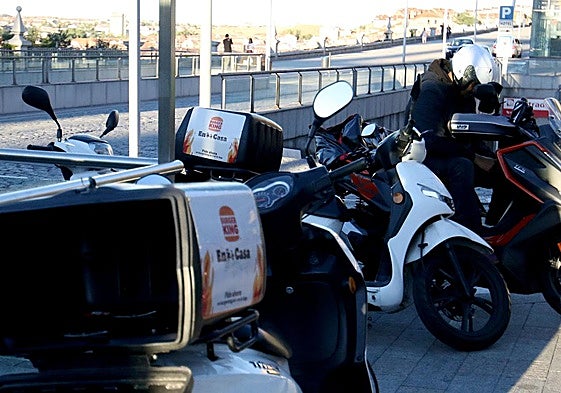 Motos usadas para el servicio de comida a domicilio aparcadas en Segovia.