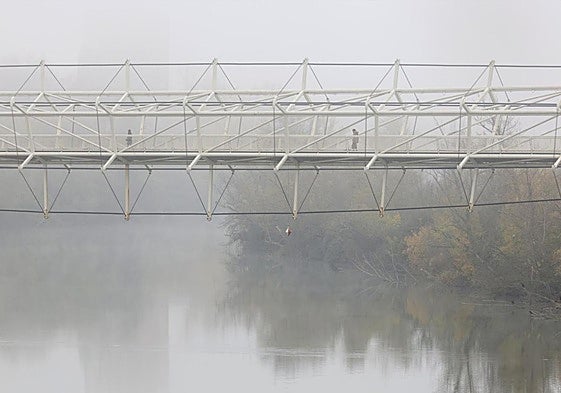 La pasarela del Museo de la Ciencia sobre el Pisuerga cubierto por la niebla en la mañana del lunes.