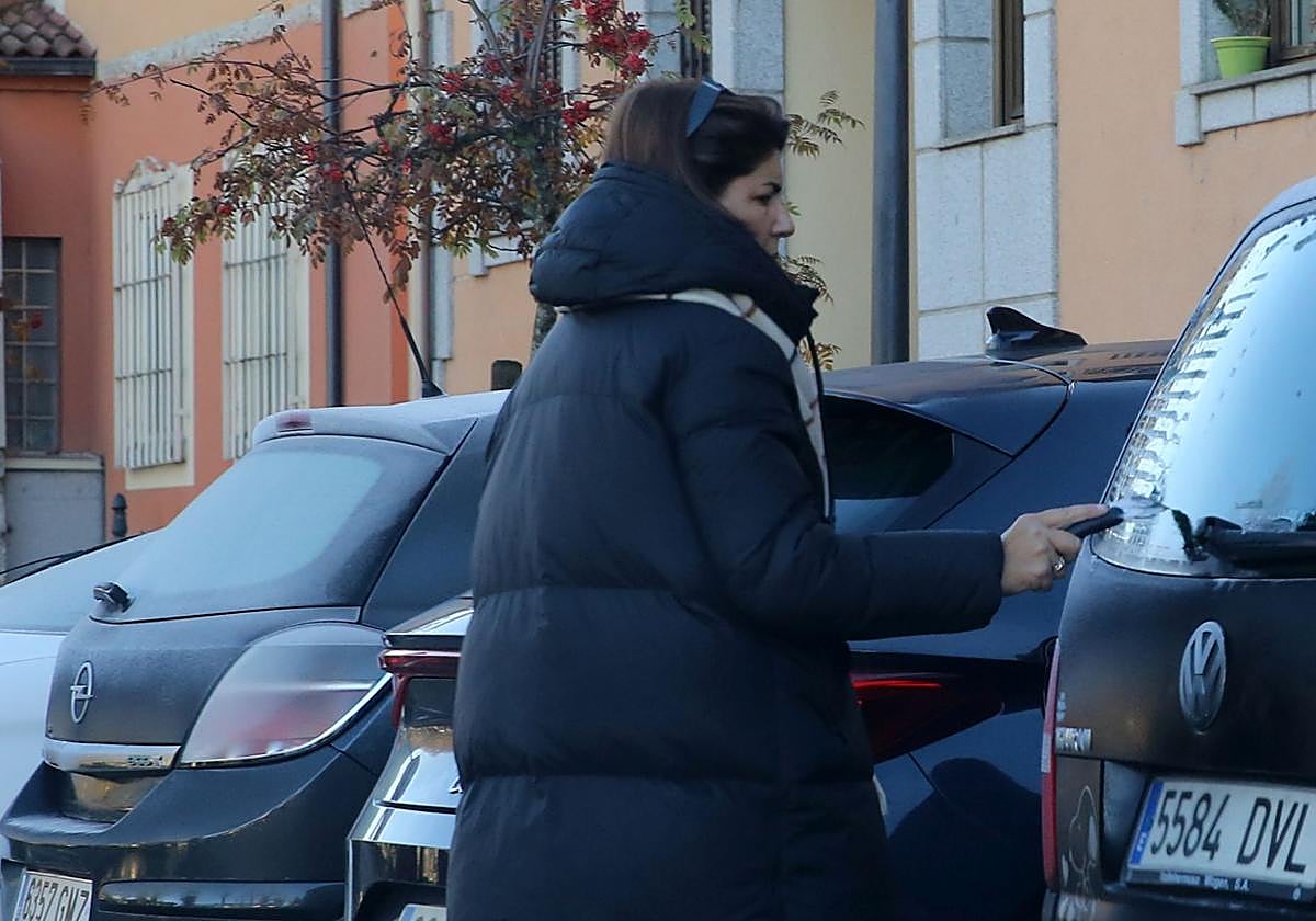 Una mujer rasca el hielo de la luna congelada de su coche este lunes.