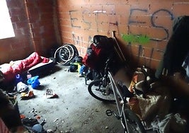 Un hombre duerme en un saco de dormir sobre un colchón y junto a su bici y su enseres en una de las estancias del abandonado residencial Rancho Grande, en el Páramo de San Isidro,