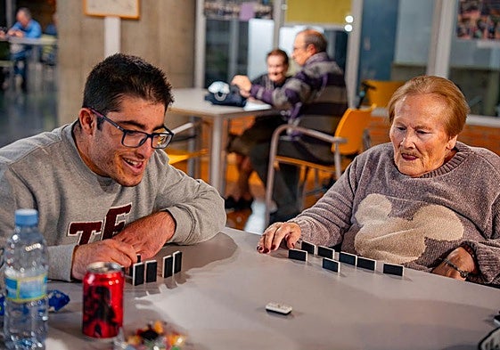 Luisa y Adrián jugando al dominó.