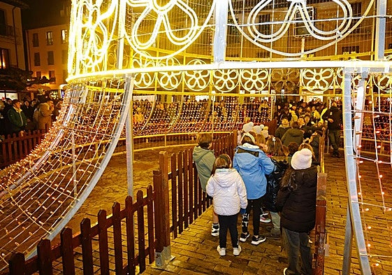 Los más pequeños atraviesan la campana de luces y sonido instalada en la Plaza Mayor.