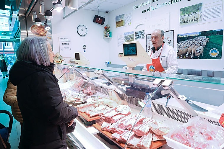 Clientas adquiriendo lechazo en el puesto de Juan Carlos Tordera en el Mercado del Val este miércoles.
