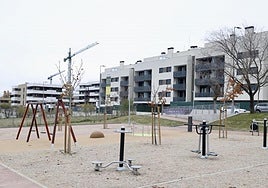 Uno de los nuevos parques inaugurados en Parquesol y, al fondo, una de las promociones en construcción en la ladera sur.