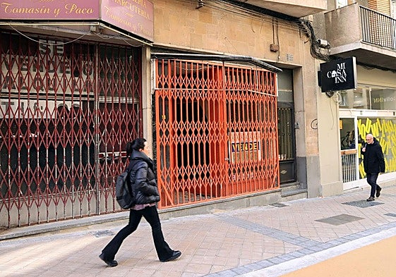 Transeúntes pasan por delante de dos locales comerciales cerrados en Blanca de Silos.
