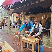 Dos vecinos colaboradores se afanan en hacer chorizos