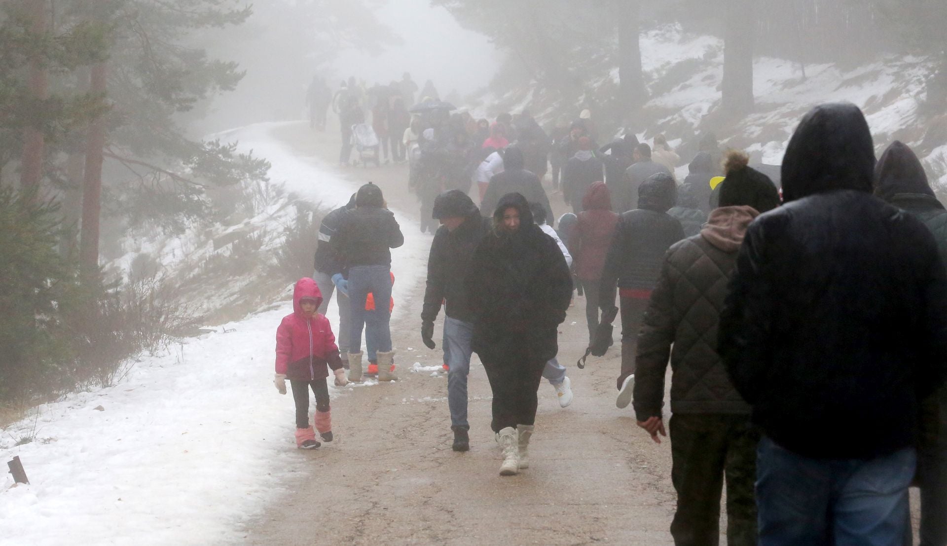 Decenas de personas pasean por el entorno del puerto de Navacerrada este sábado.