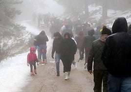Decenas de personas pasean por el entorno del puerto de Navacerrada este sábado.