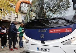 Varias personas esperan turno en Palencia para subir a un autobús.