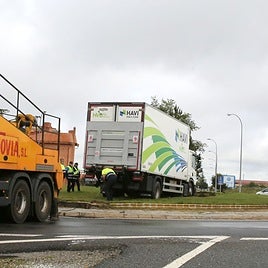 Operarios tratan de sacar el camión de la rotonda.
